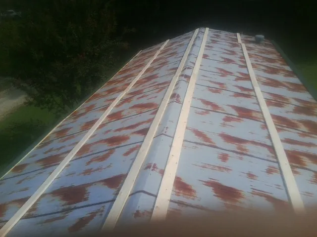 Rusted metal roof panels with new wood purlins before replacement — Storm Damage Roof Repair in Winston by Roofing Brothers